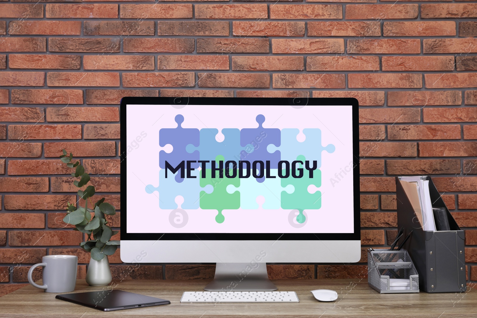 Image of Methodology concept. Workplace with modern computer on wooden table near brick wall