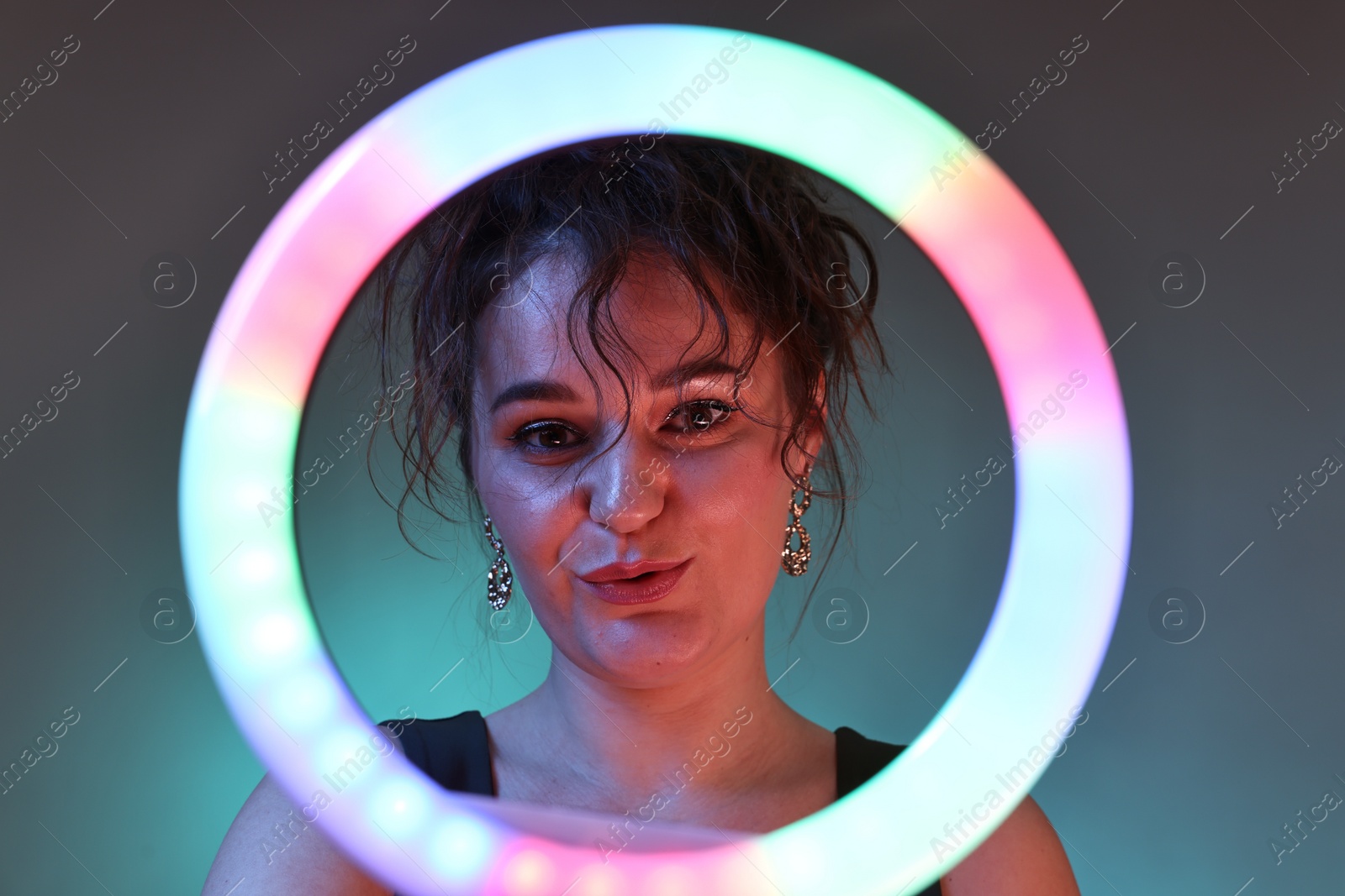 Photo of Portrait of beautiful woman with ring light on dark background