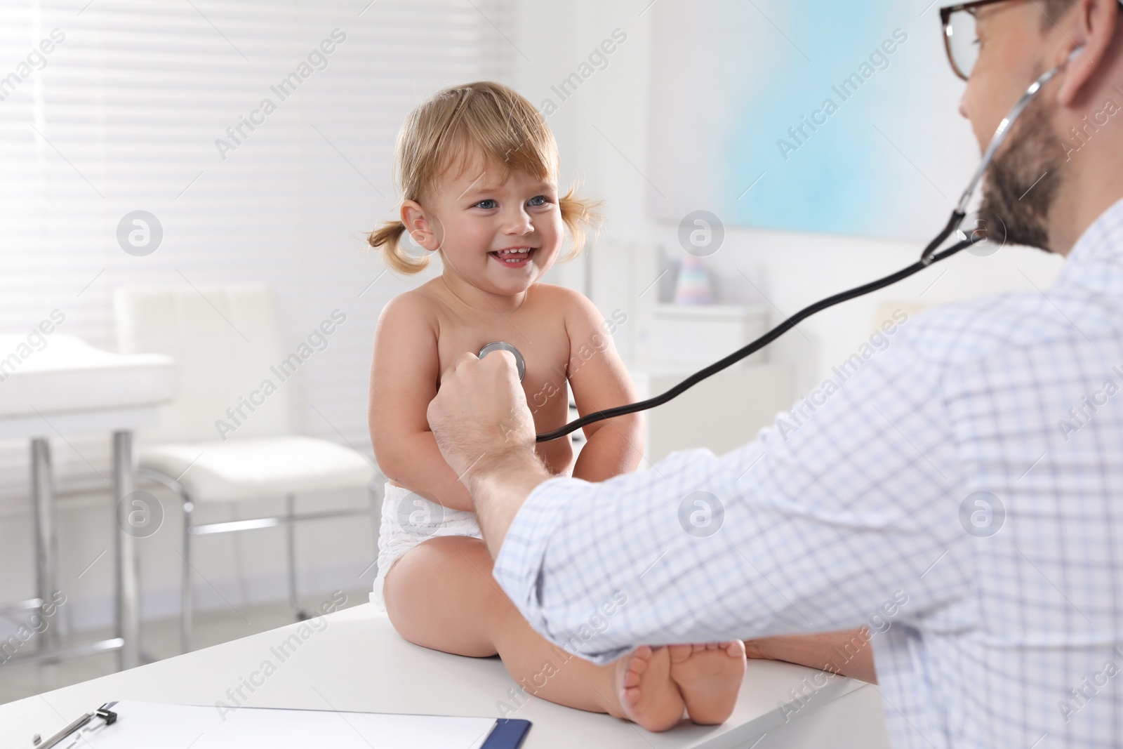 Photo of Pediatrician examining baby with stethoscope in clinic