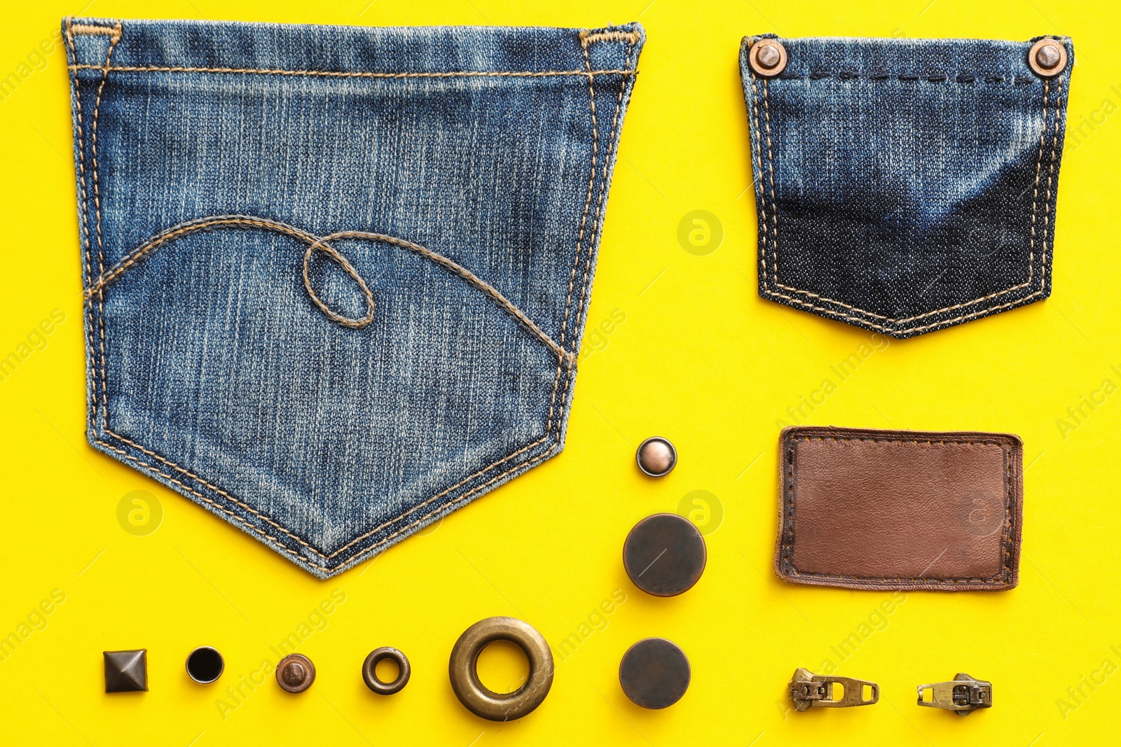 Photo of Flat lay composition with garment accessories and cutting details for jeans on yellow background