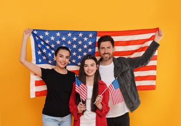 4th of July - Independence Day of USA. Happy family with American flags on yellow background