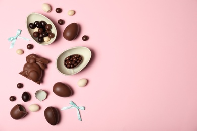 Photo of Flat lay composition with chocolate Easter eggs and space for text on color background