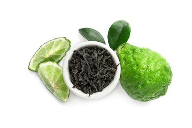 Dry bergamot tea leaves in bowl and fresh fruits on white background, top view