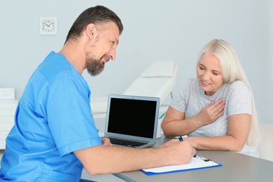 Photo of Male medical assistant consulting female patient in clinic