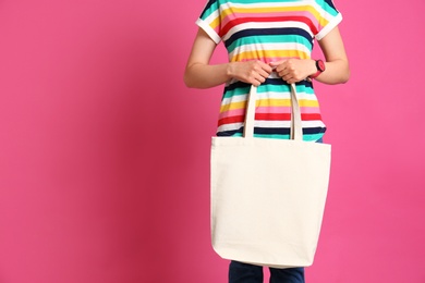 Photo of Woman with stylish blank eco bag against color background, closeup. Space for text