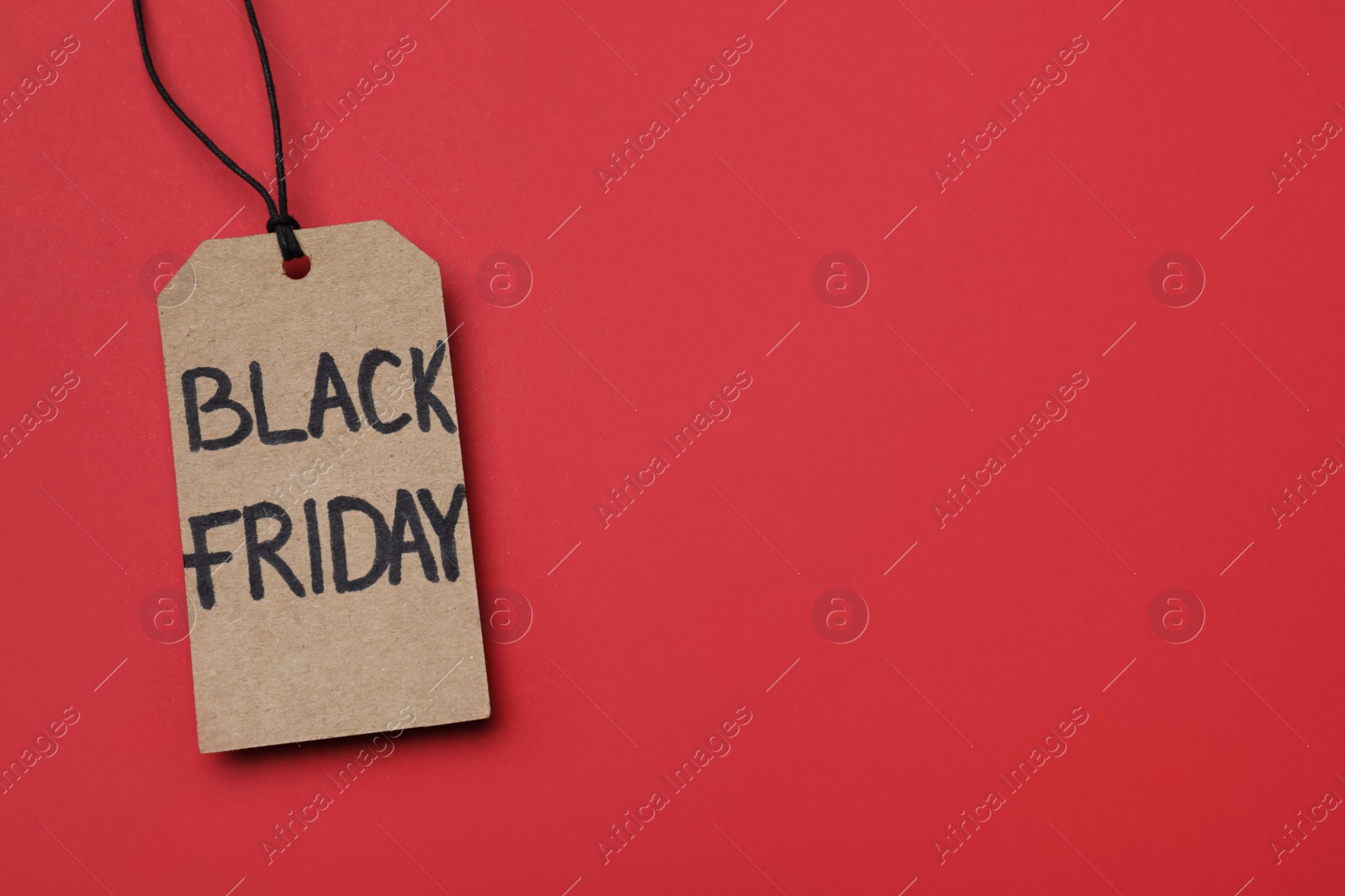 Photo of Tag with words Black Friday on red background, top view. Space for text