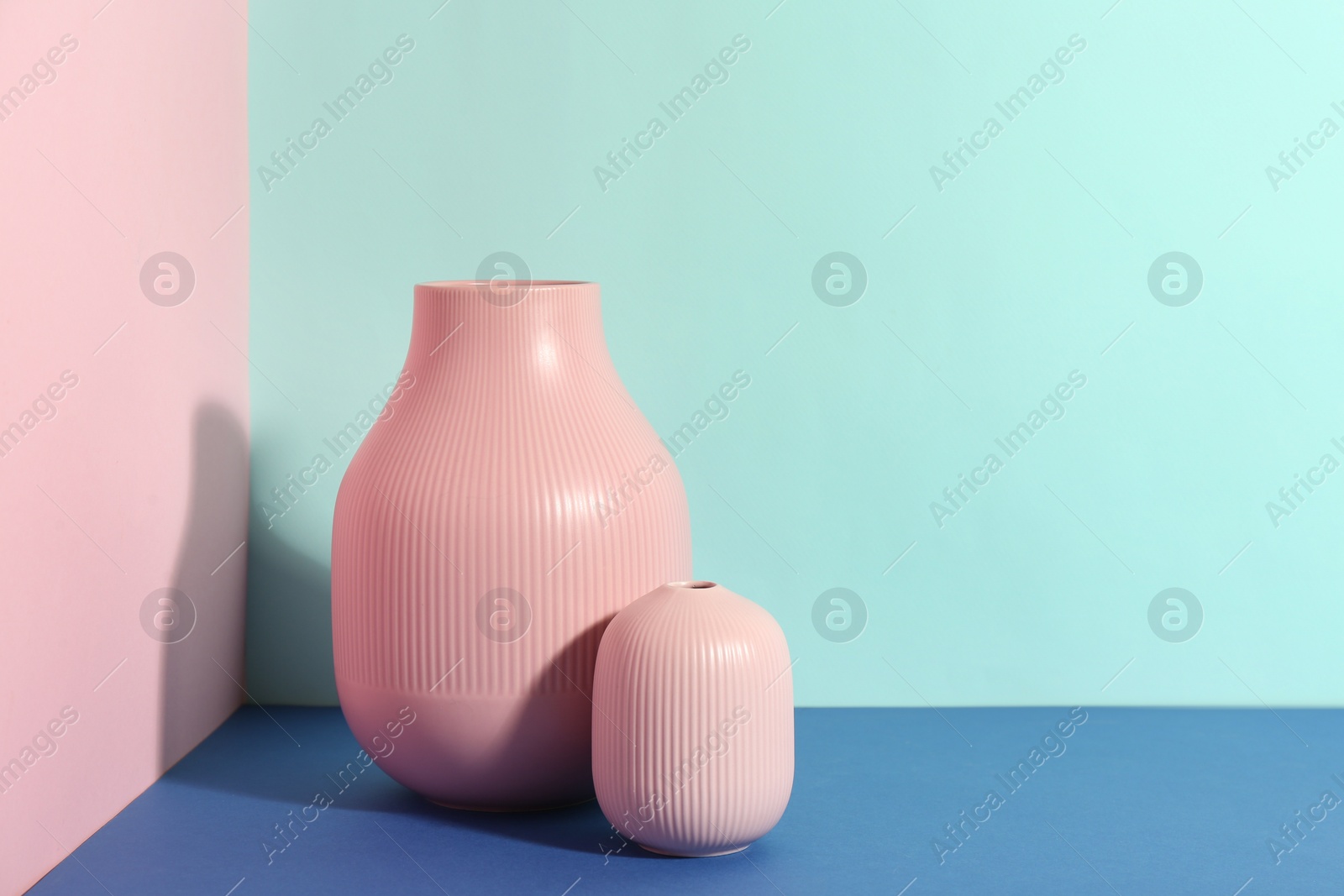 Photo of Stylish empty ceramic vases on color background, space for text