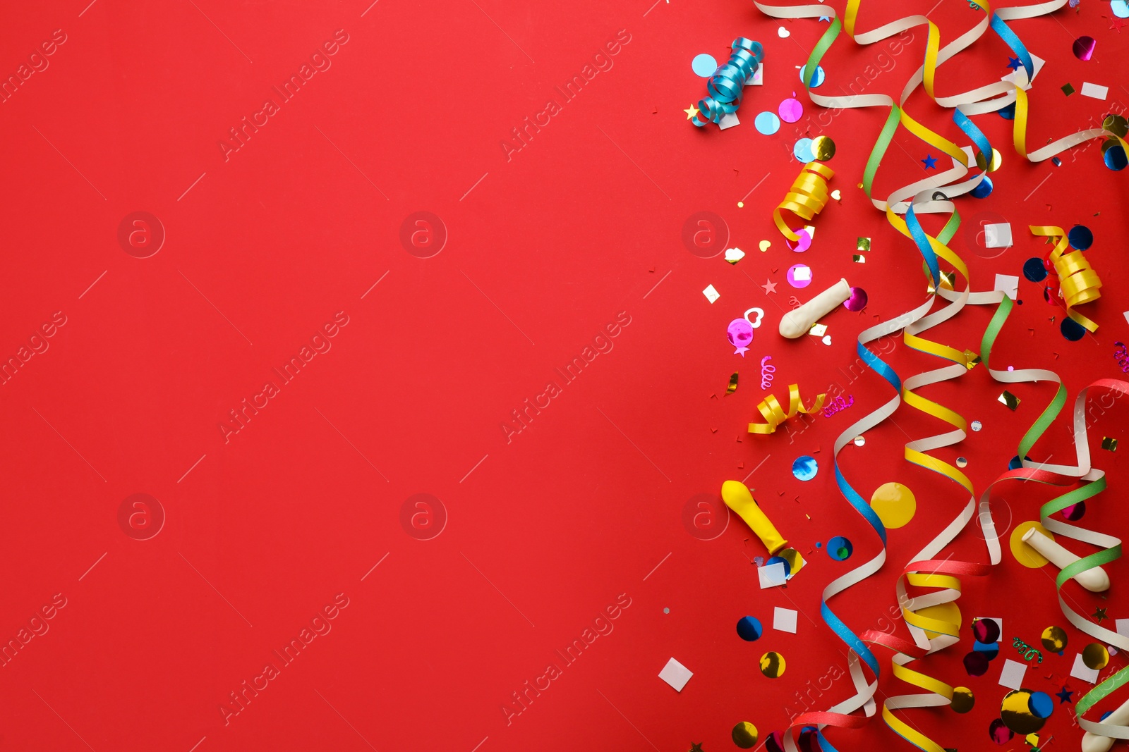 Photo of Flat lay composition with carnival items on red background. Space for text