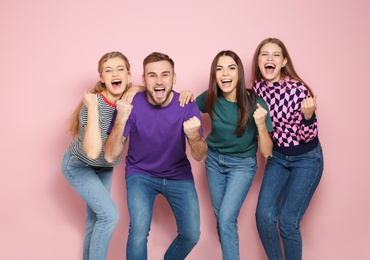 Photo of Young people celebrating victory on color background