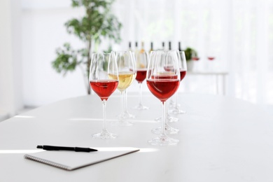 Photo of Glasses with delicious wine on table indoors