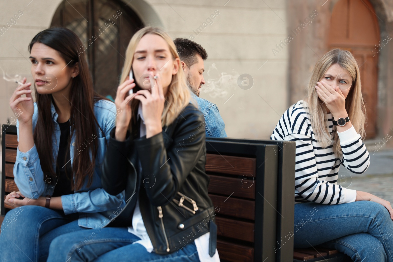 Photo of People smoking cigarettes at public place outdoors