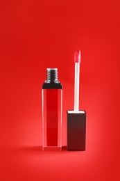 Photo of Liquid lipstick tube with applicator on color background