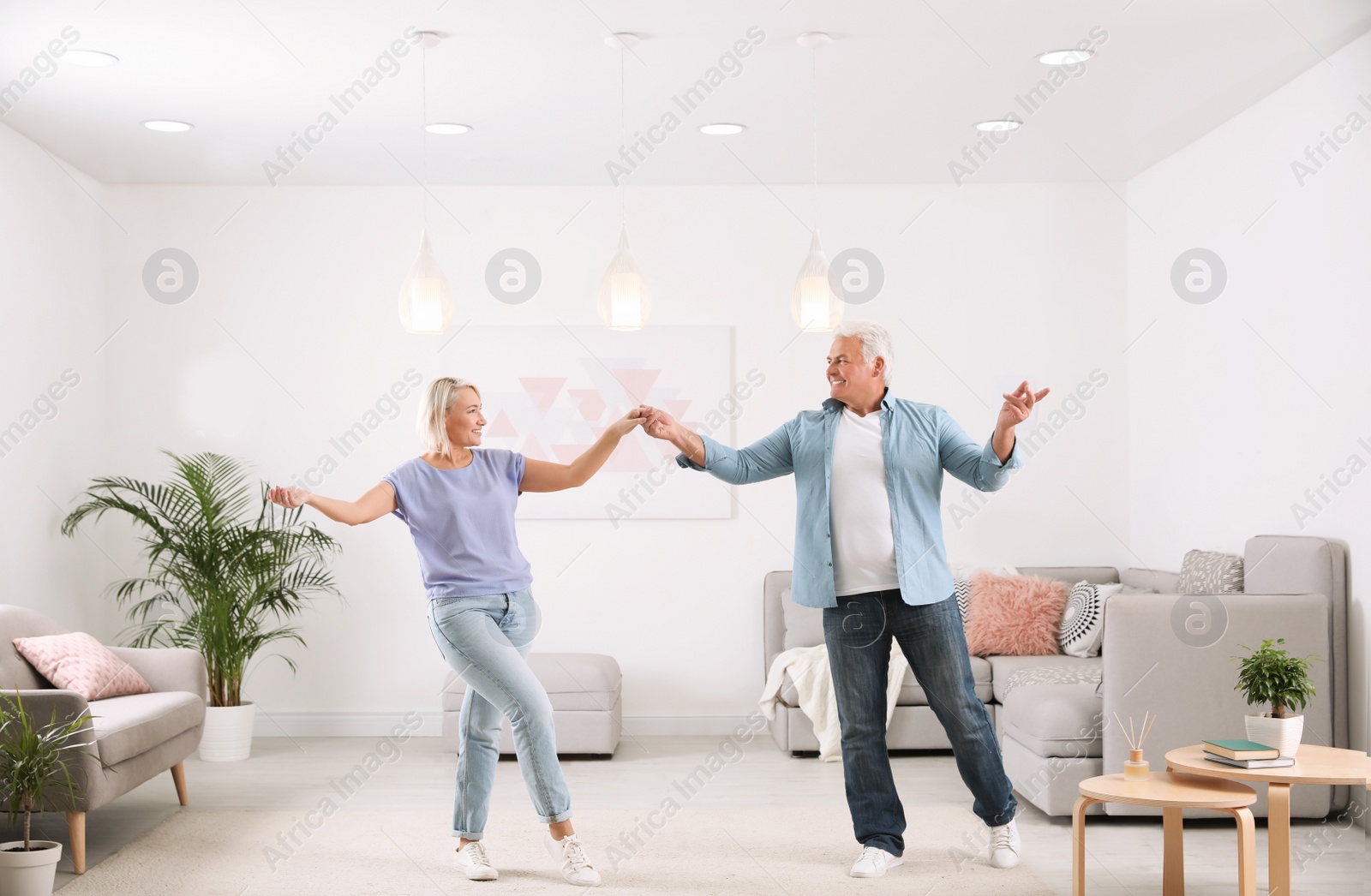 Photo of Happy mature couple dancing together in living room