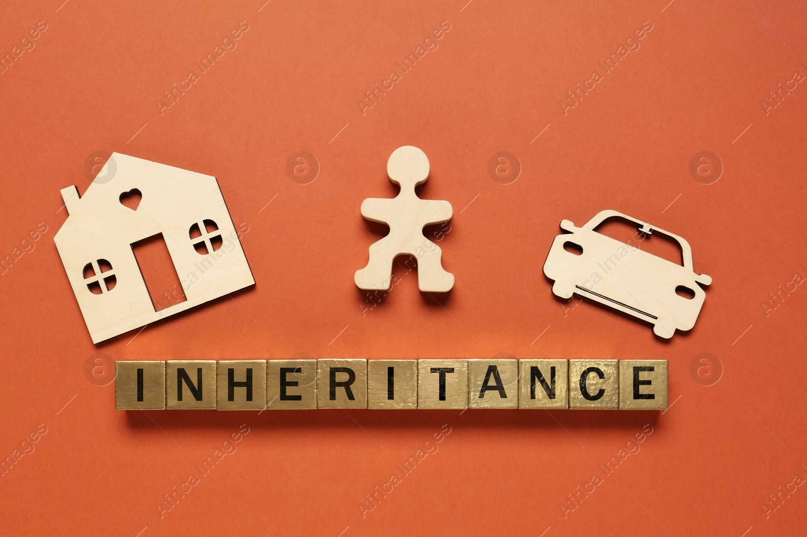 Photo of Word Inheritance made with cubes and different cutouts on orange background, flat lay