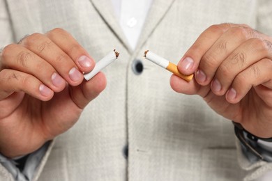 Photo of Stop smoking concept. Closeup view of man breaking cigarette