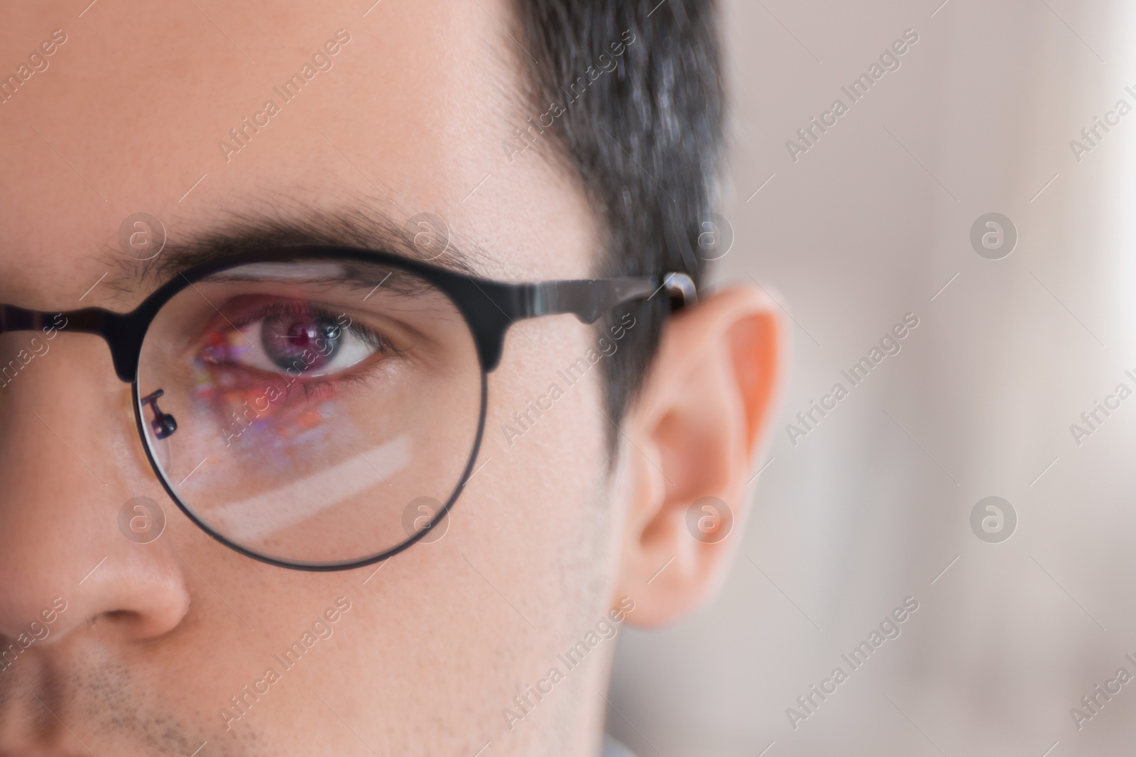 Photo of Man wearing glasses on blurred background, closeup