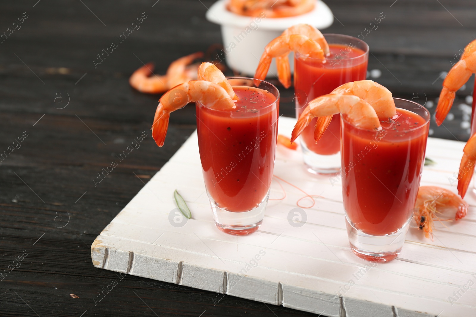 Photo of Delicious shrimp cocktail with tomato sauce served on black wooden table