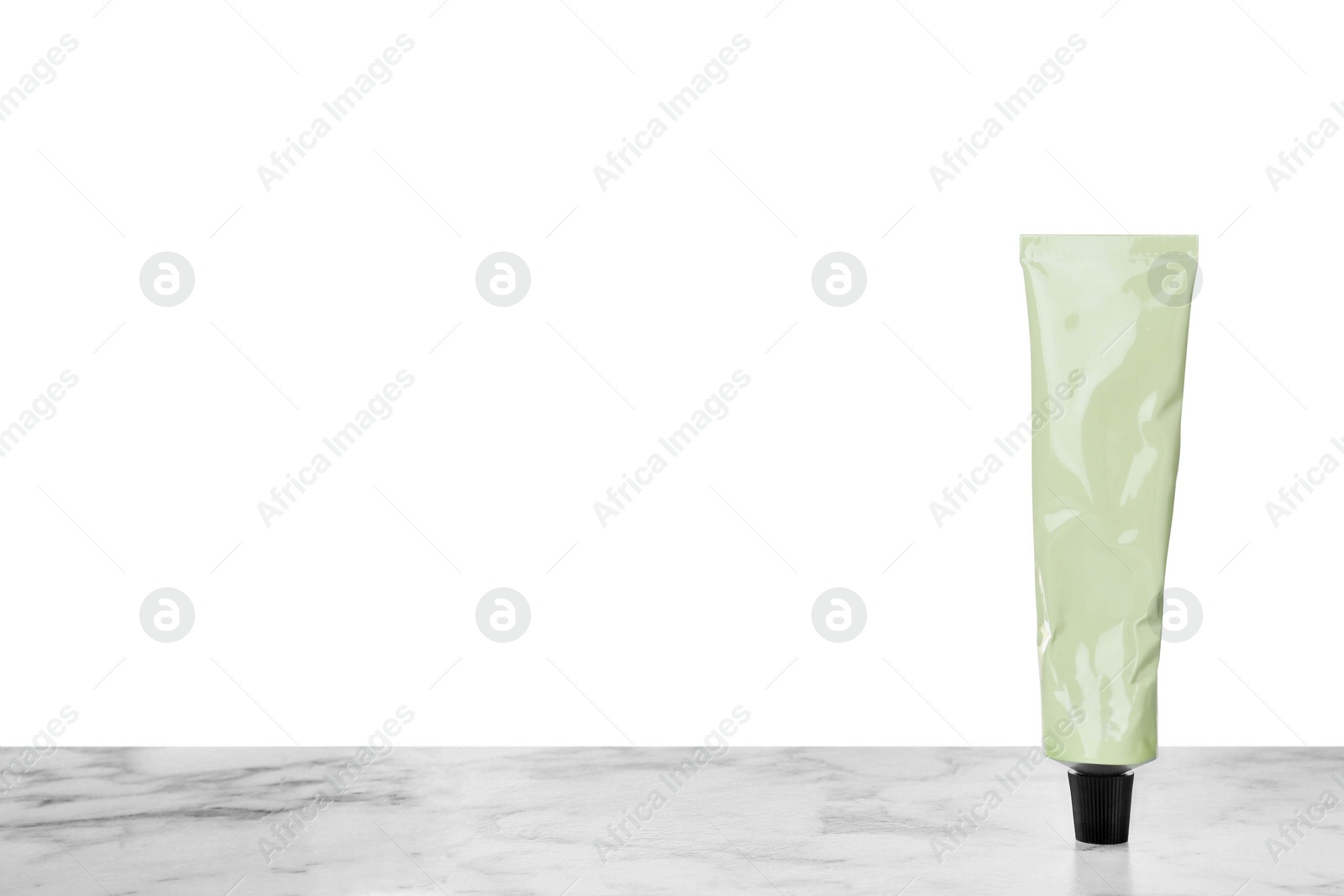 Photo of Tube of hand cream on gray table against white background