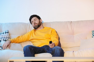 Photo of Man sleeping while watching TV on sofa