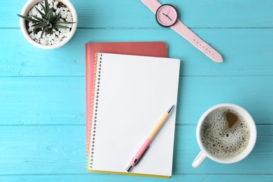 Photo of Flat lay composition with office stationery and cup of coffee on light blue wooden table