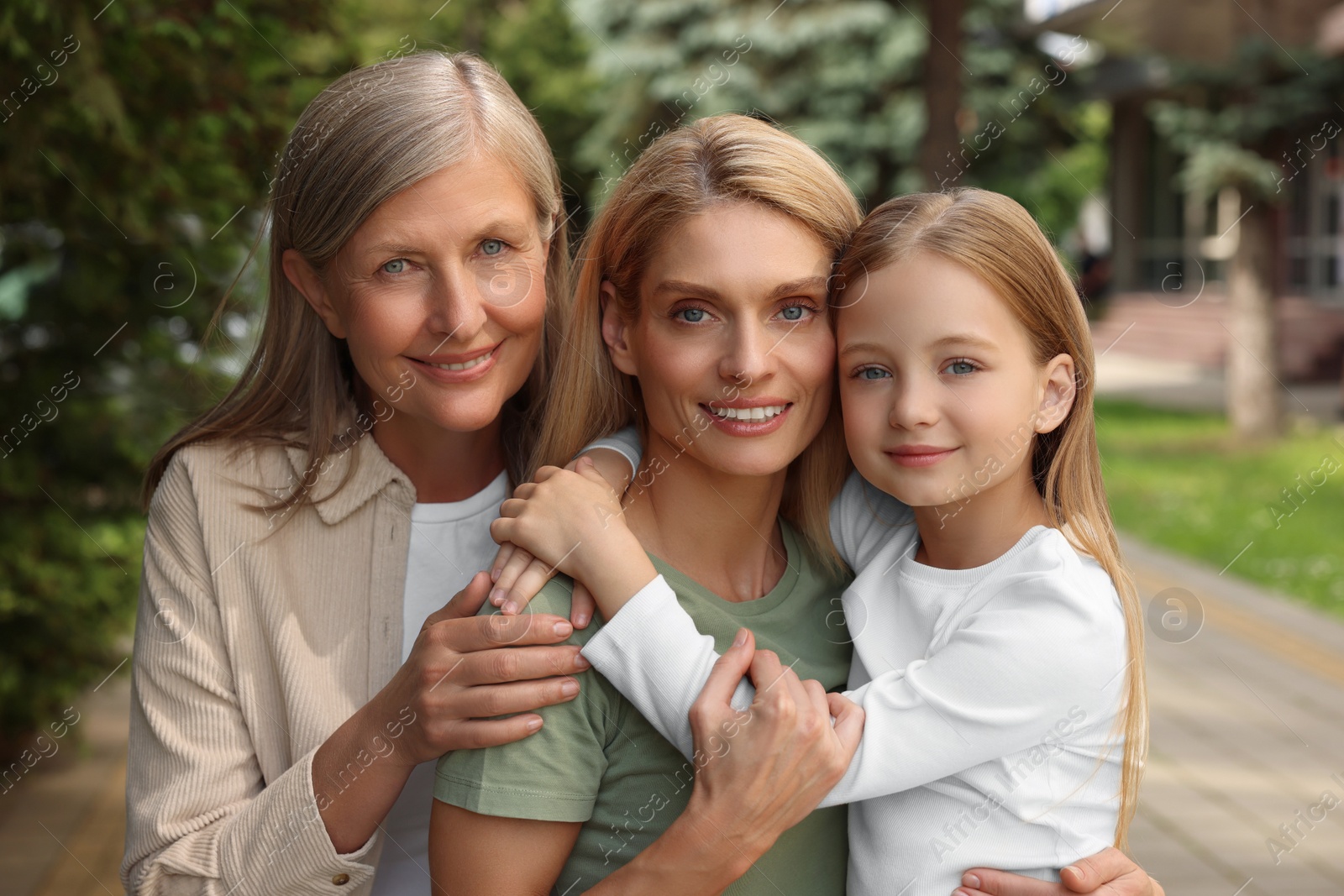 Photo of Three generations. Happy grandmother, her daughter and granddaughter outdoors