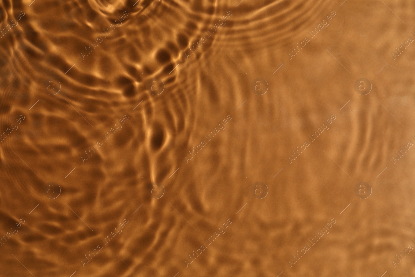 Photo of Closeup view of water with circles on brown background