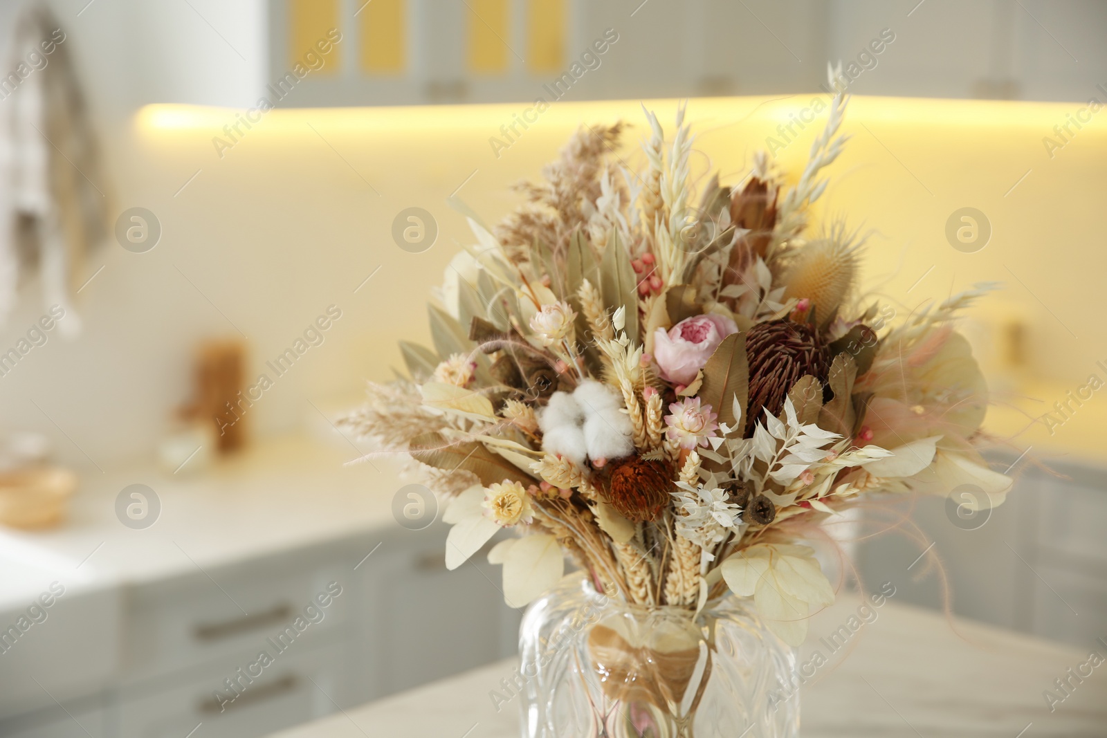 Photo of Bouquet of dry flowers and leaves on table in kitchen
