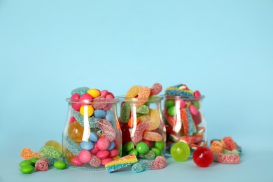 Photo of Jars with different delicious candies on light blue background