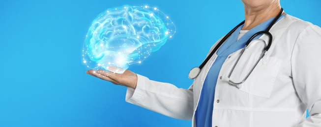 Image of Mature doctor holding digital image of brain in palm on blue background, closeup. Banner design 