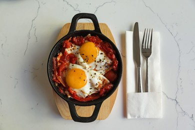 Photo of Tasty Shakshouka served on white marble table, flat lay