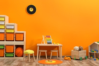 Photo of Stylish children's room interior with toys and new furniture