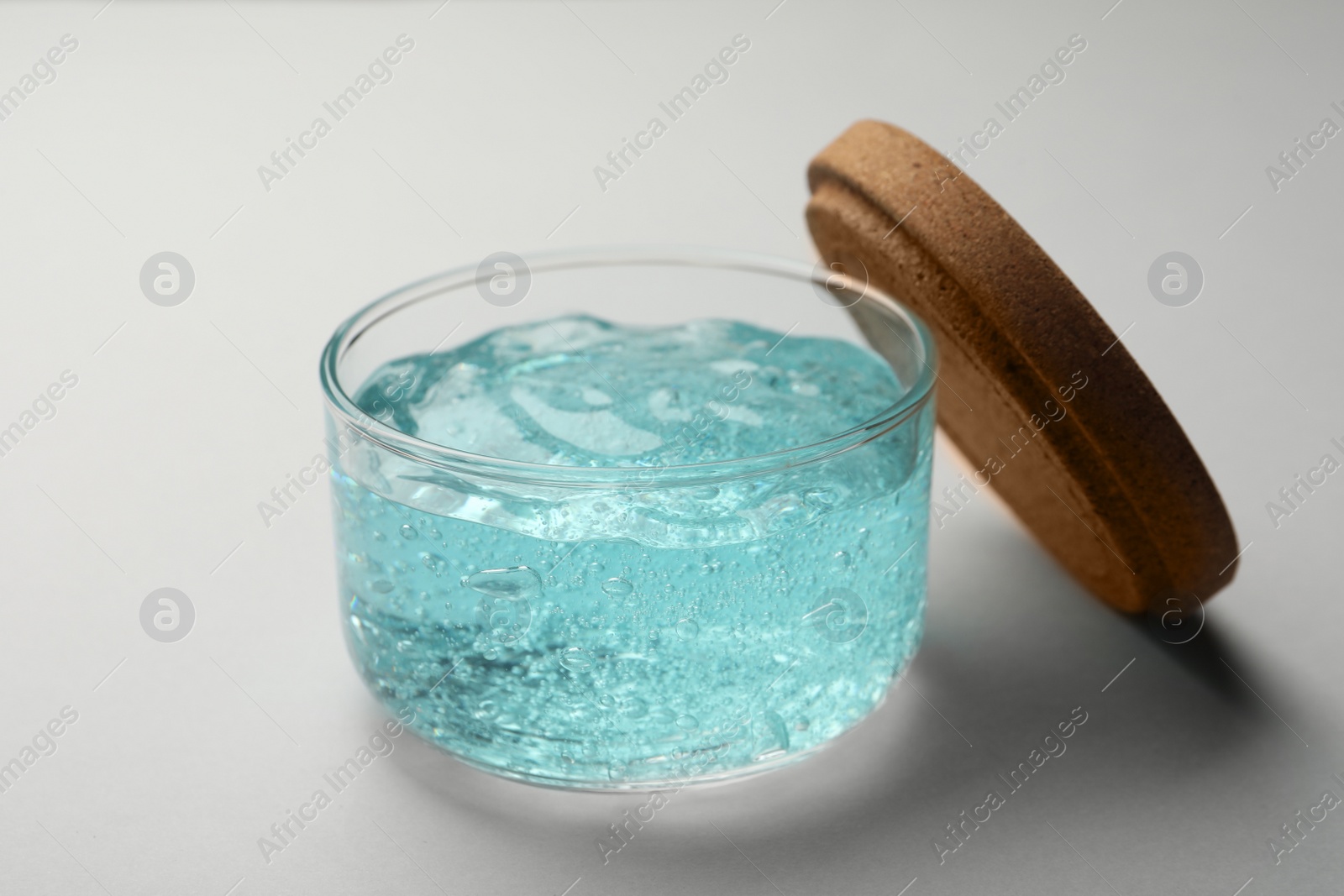 Photo of Jar of blue cosmetic gel on light background