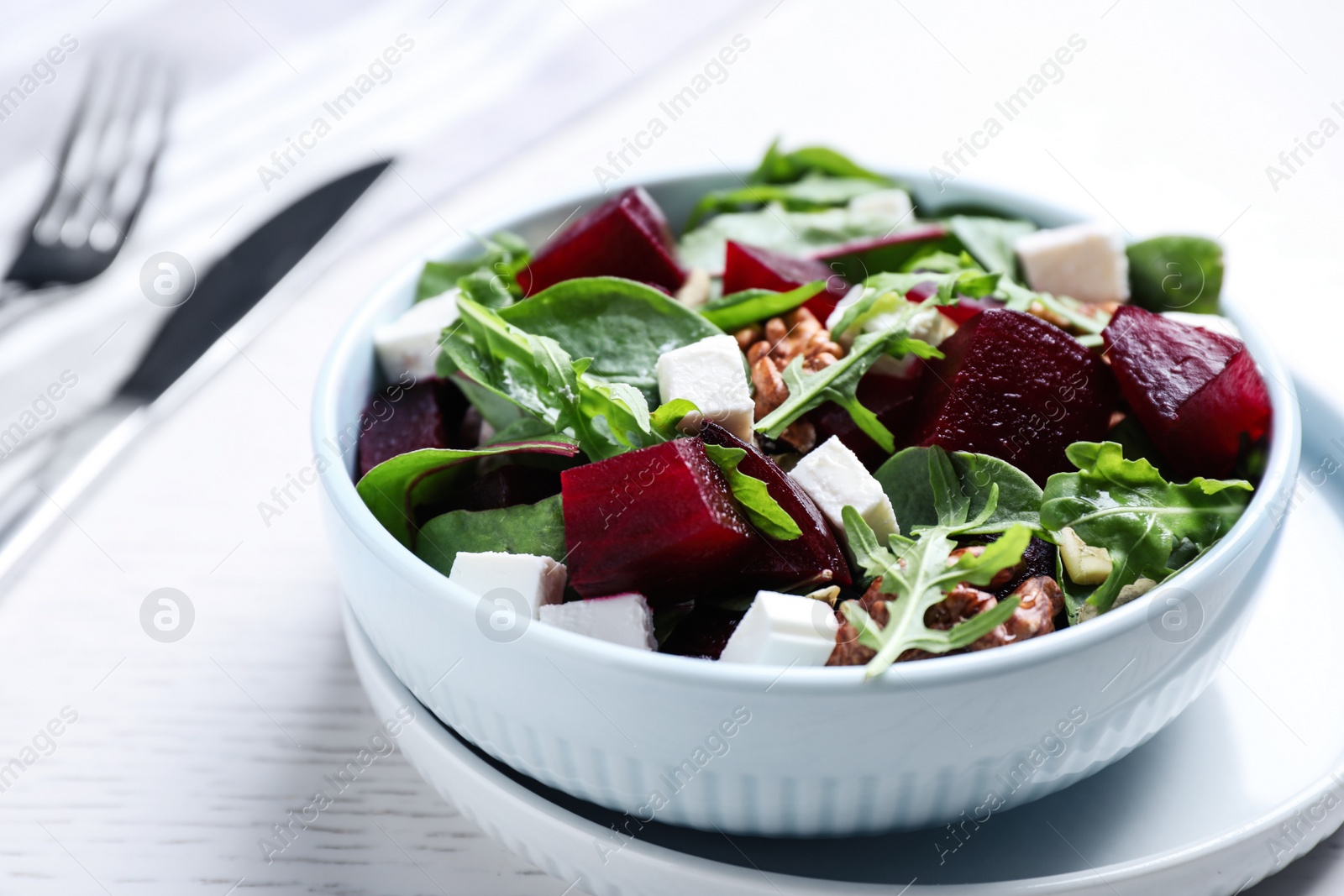 Photo of Delicious beet salad served on white wooden table, closeup