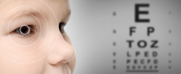 Image of Vision test chart and laser reticle focused on boy's eye against grey background, closeup. Banner design