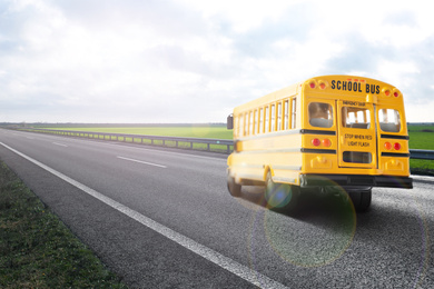 Image of Yellow school bus on road outdoors. Transport for students