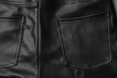 Photo of Black leather trousers with pocket as background, top view