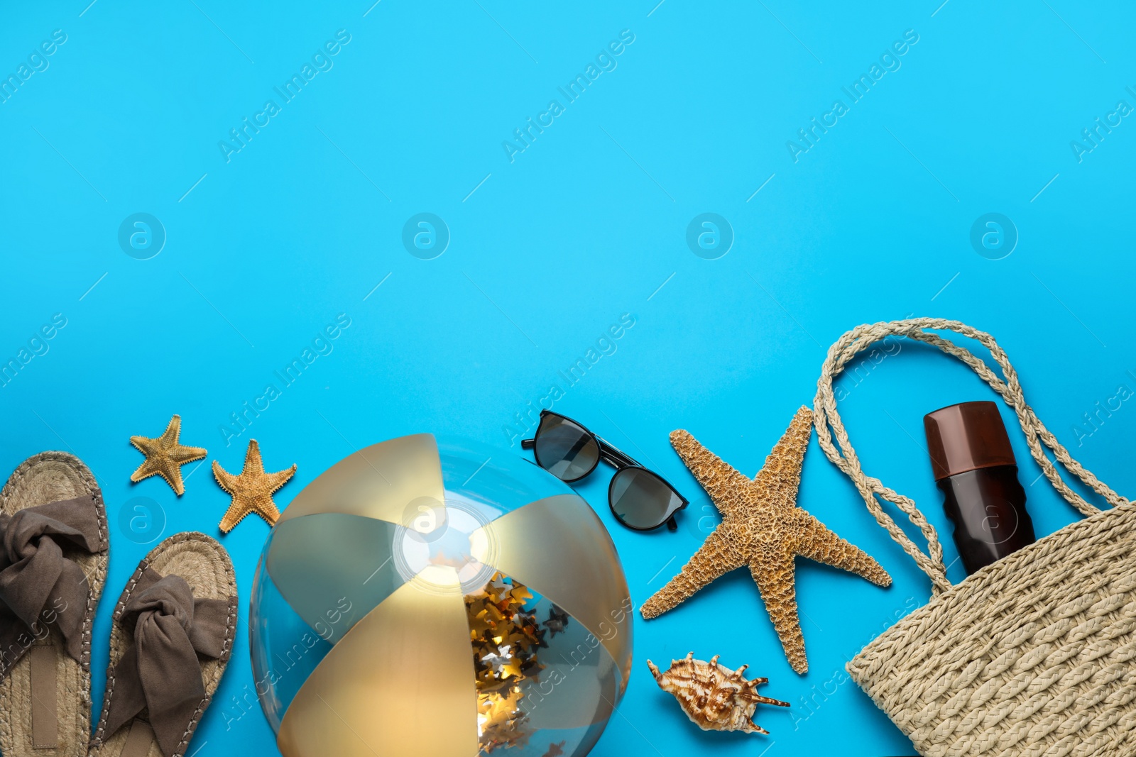 Photo of Flat lay composition with ball and beach objects on light blue background