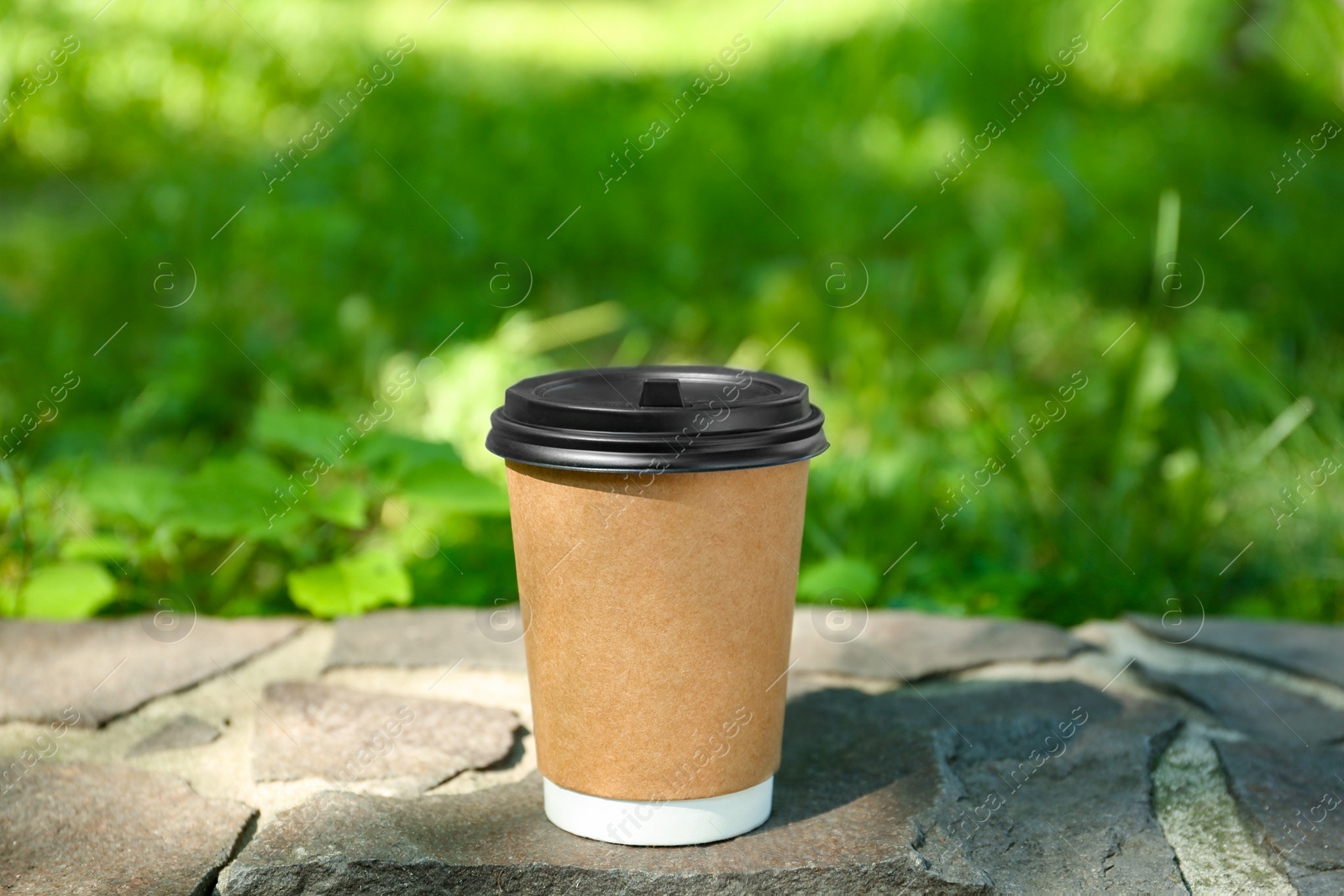 Photo of Paper cup on border outdoors. Takeaway drink