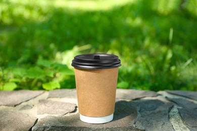 Photo of Paper cup on border outdoors. Takeaway drink