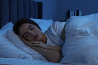 Photo of Beautiful young woman sleeping in bed at night