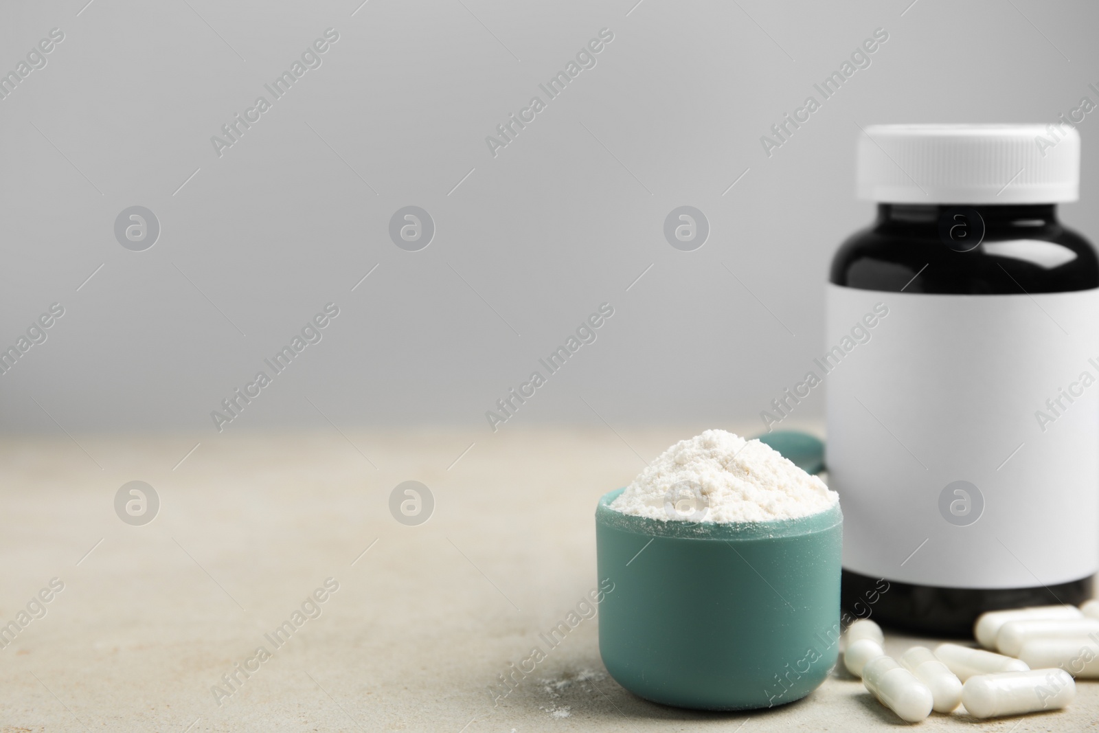 Photo of Amino acid pills and powder on grey table. Space for text