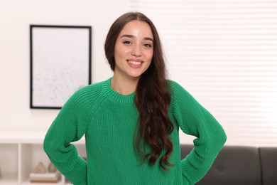 Photo of Beautiful young woman in stylish warm sweater at home