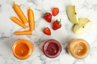 Photo of Healthy baby food in jars and fresh ingredients on white marble table, flat lay