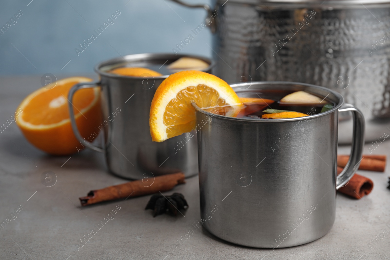 Photo of Tasty mulled wine with spices on grey table