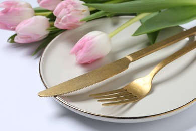 Photo of Stylish table setting with cutlery and tulips on white background, closeup