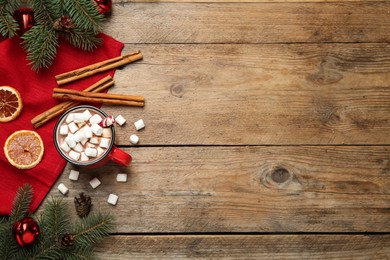 Photo of Flat lay composition of delicious hot chocolate with marshmallows and Christmas decor on wooden table, space for text