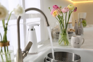 Photo of Light kitchen decorated with beautiful fresh ranunculus flowers