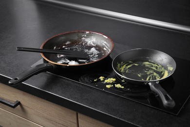 Photo of Dirty frying pans on cooktop in kitchen