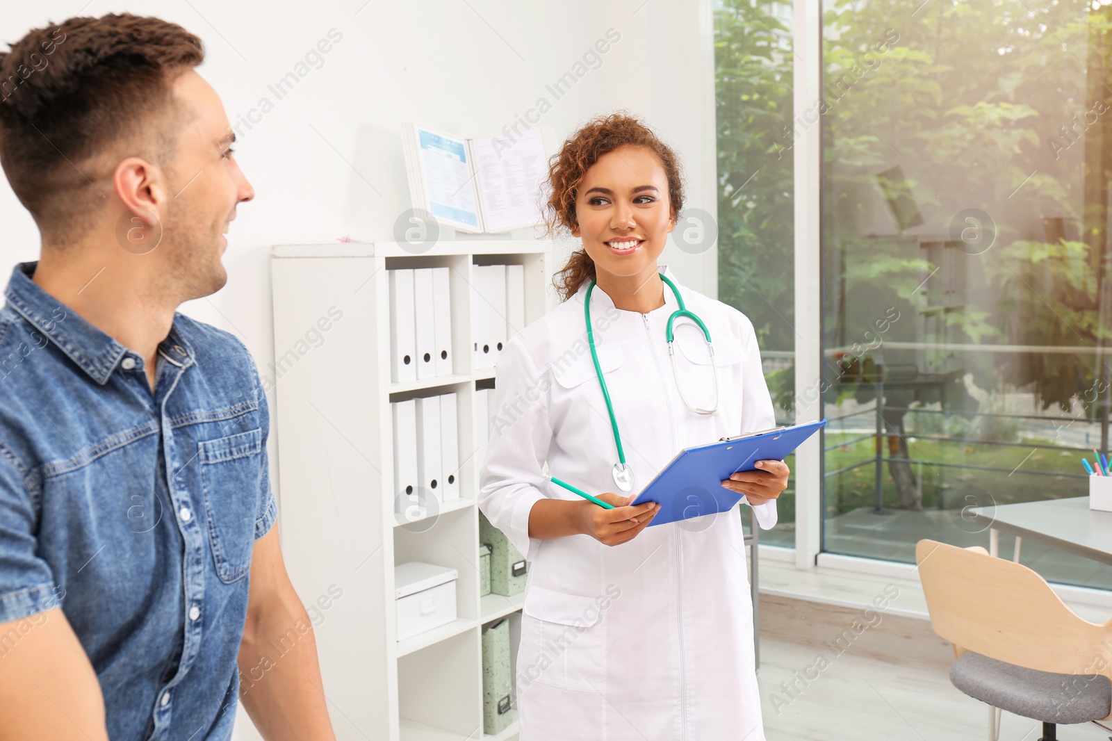 Photo of African American doctor working with patient in hospital