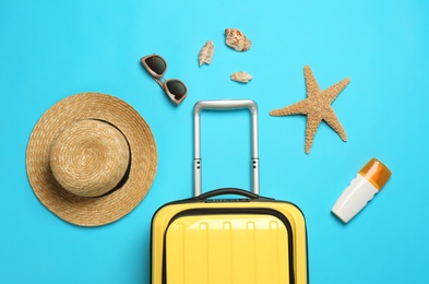 Photo of Flat lay composition with suitcase and beach items on color background